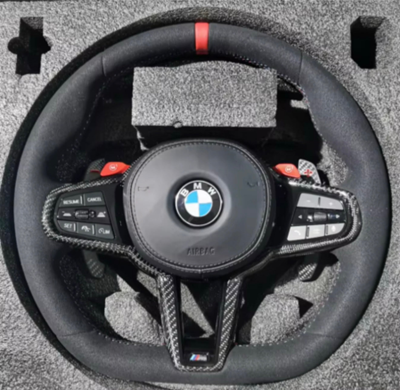 BMW custom steering wheel with controls on a textured surface