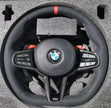 BMW custom steering wheel with controls on a textured surface